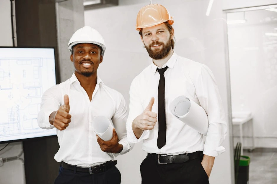 Zespół inżynierów i pracowników budowlanych omawiający plany na budowie